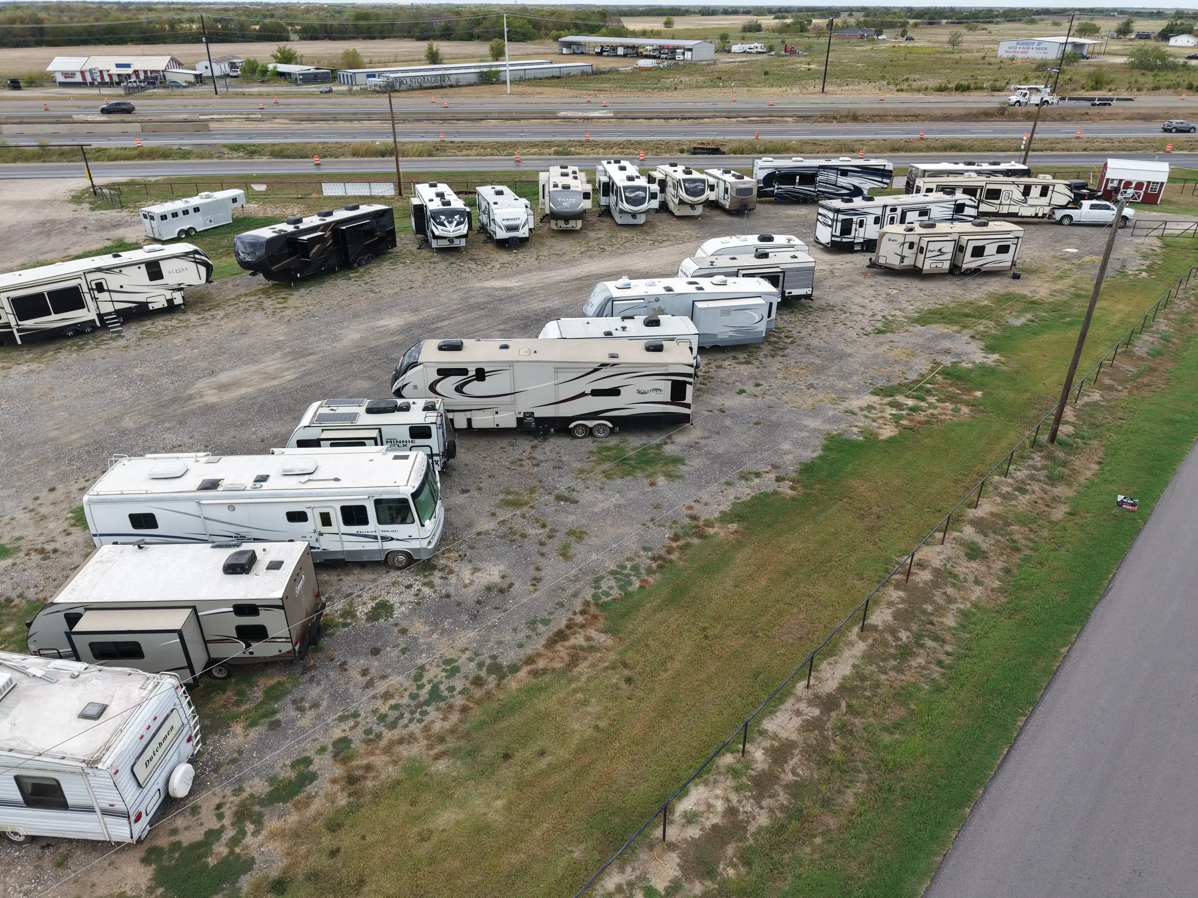 Pre-owned RVs parked in diagonal rows at BK Consignments in Greenville, Texas, seen from above