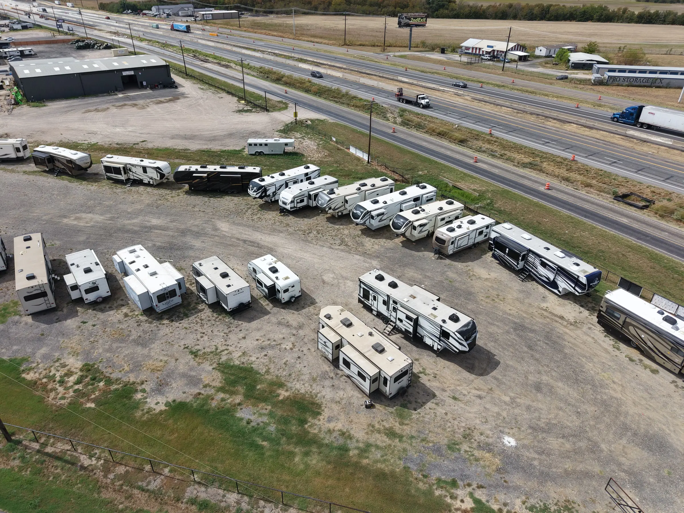 Rows of consigned RVs beside Interstate 30 traffic at BK Consignments between Caddo Mills and Greenville, Texas