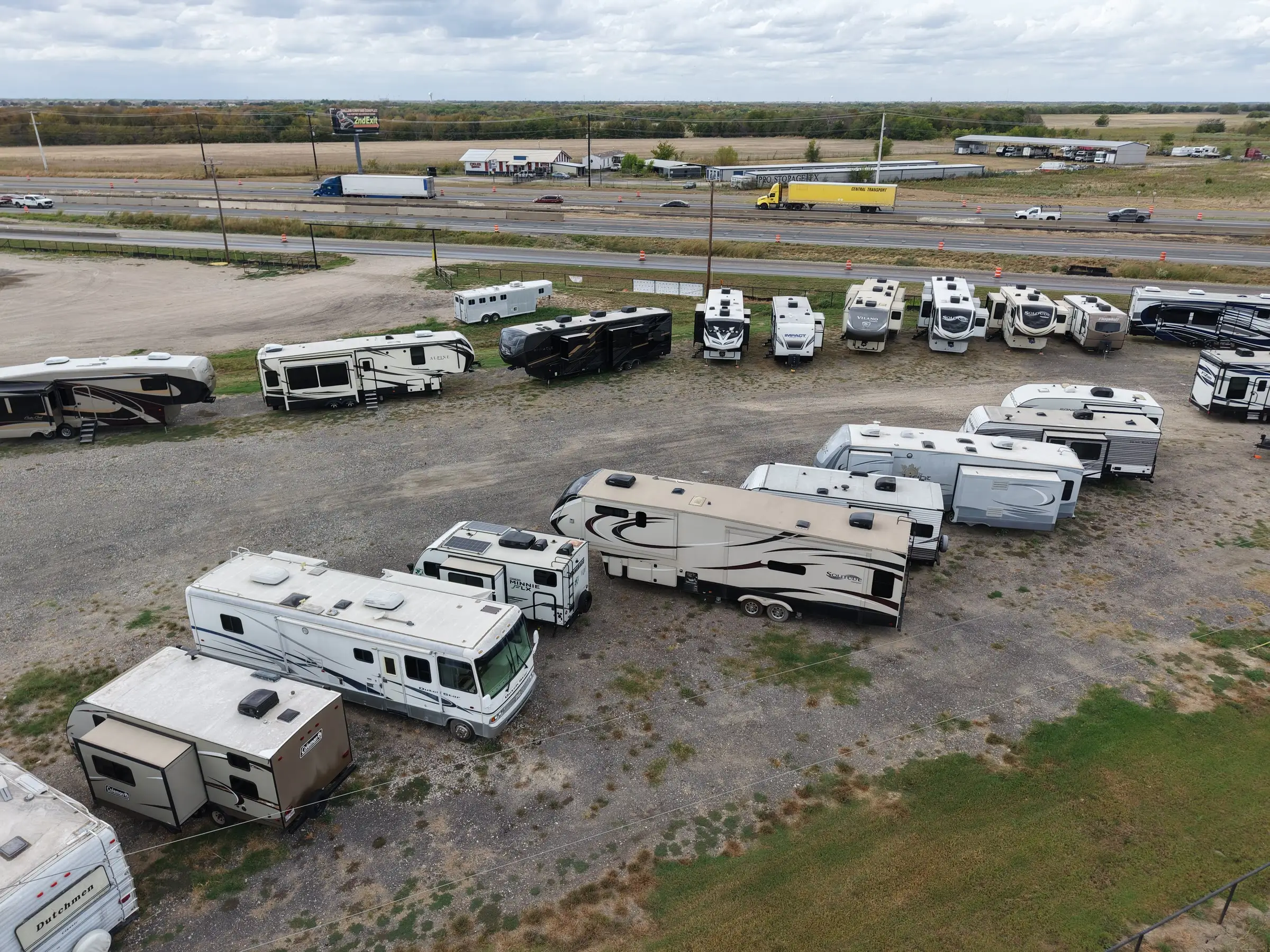 Rows of RVs for sale at BK Consignments right beside Interstate 30 in Greenville, Texas, seen from a drone